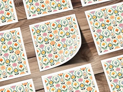 Floral pattern on paper squares scattered on a wooden surface.