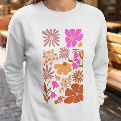 Crewneck sweatshirt with a collage of retro-style floral illustrations in pink, orange, and brown.