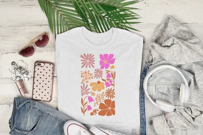 White t-shirt with abstract floral pattern in pink, orange, and brown.