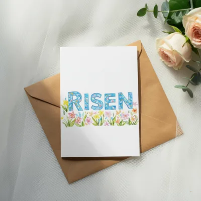Card with "RISEN" in colorful floral lettering on a brown envelope.