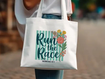 White canvas tote bag with "Run the Race" and floral design.