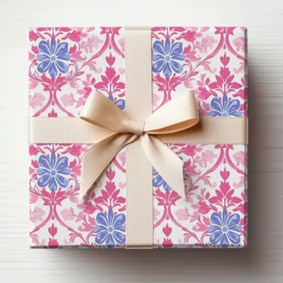 Gift box with pink and blue floral pattern and beige ribbon bow.