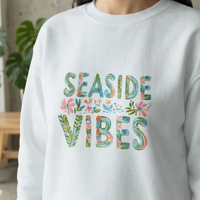 White sweatshirt with "SEASIDE VIBES" in floral lettering.