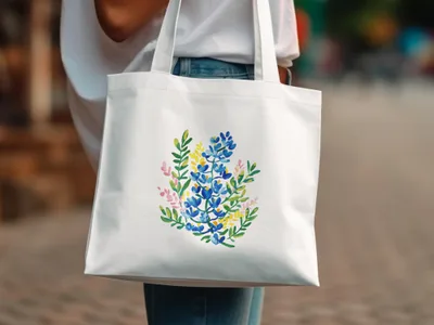 White tote bag with a watercolor floral design in blue, yellow, and pink.