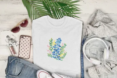 White t-shirt with a floral bouquet illustration in blue, yellow, and pink.