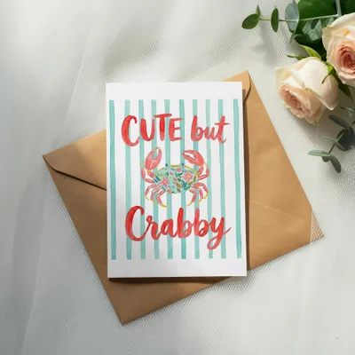 Card with "CUTE but Crabby" text and watercolor crab and flowers.