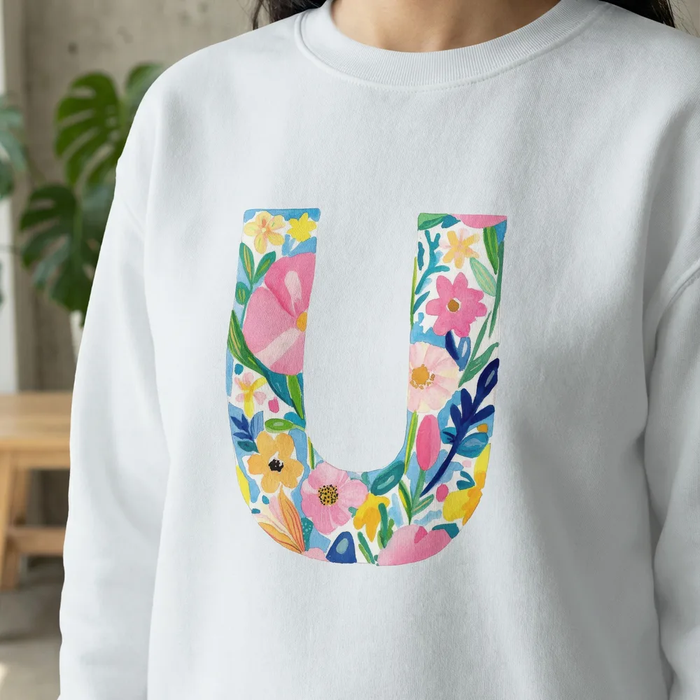 White sweatshirt with a large floral letter U design.