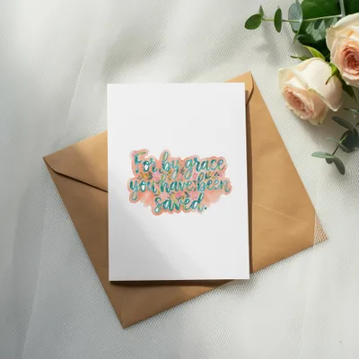 Card with "For by grace you have been saved" text, next to envelope and roses.