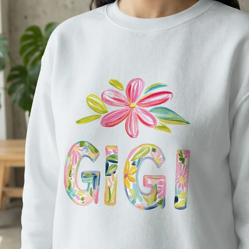 White sweatshirt with colorful floral "Gigi" lettering and painted flower.