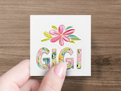 Gigi text with floral accents held by a hand.