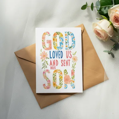 Card with floral text "God loved us and sent his Son" on an envelope.