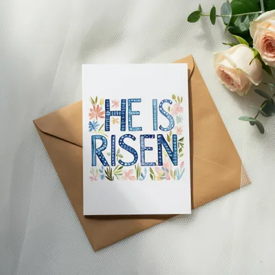Card with "He is Risen" in decorative lettering and floral accents.