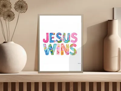 Colorful floral letters spell "Jesus Wins" in a framed print.