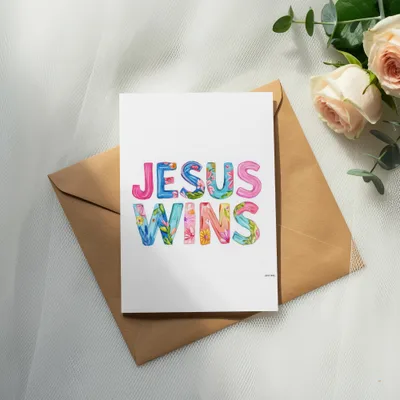 Card with "JESUS WINS" in colorful watercolor lettering on a brown envelope.