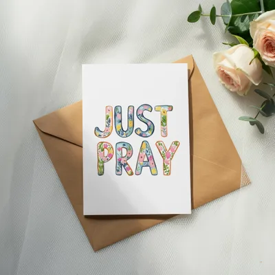 Card with "JUST PRAY" text in floral lettering on an envelope.