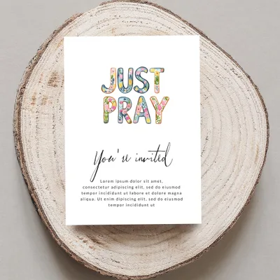 Card with "JUST PRAY" and "You're invited" text, on a wood slice.