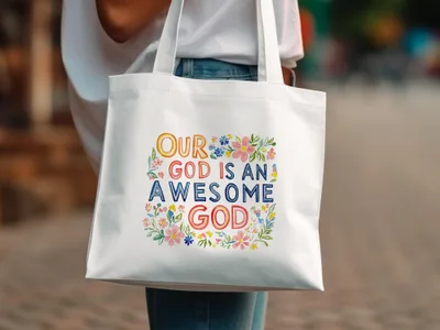 White canvas tote bag with "Our God is an Awesome God" in colorful lettering and floral accents.