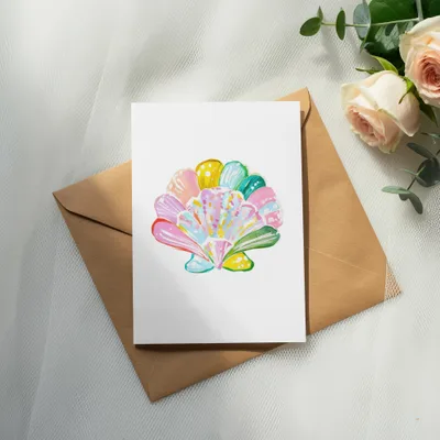 White card with a colorful seashell illustration on a brown envelope.