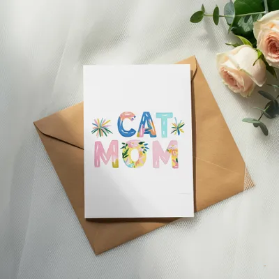 Greeting card with "CAT MOM" in colorful floral lettering on brown envelope.