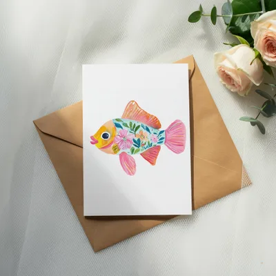 Greeting card with a colorful floral fish illustration on a brown envelope.