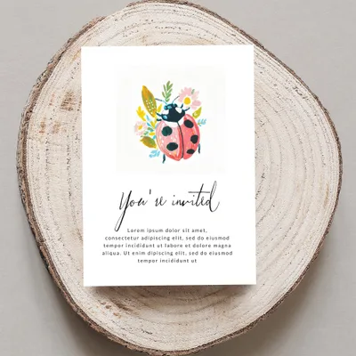 Ladybug invitation with floral accents and placeholder text.