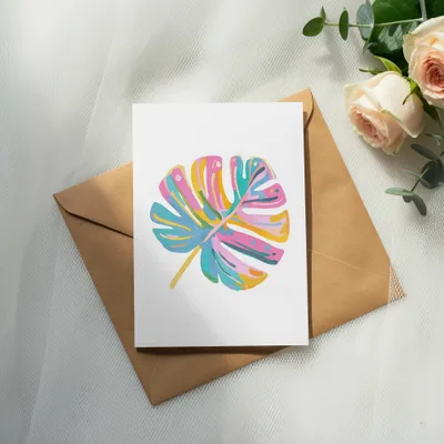 Card with colorful abstract monstera leaf design on envelope, with roses.