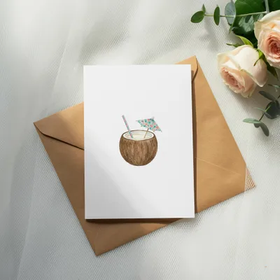 Coconut drink with straw and umbrella on a card, with envelope and flowers.