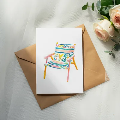 Watercolor illustration of a striped beach chair on a brown envelope with roses.