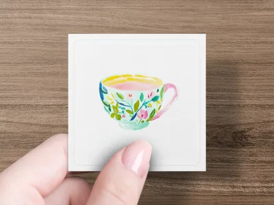 Watercolor teacup with floral design held by a hand.