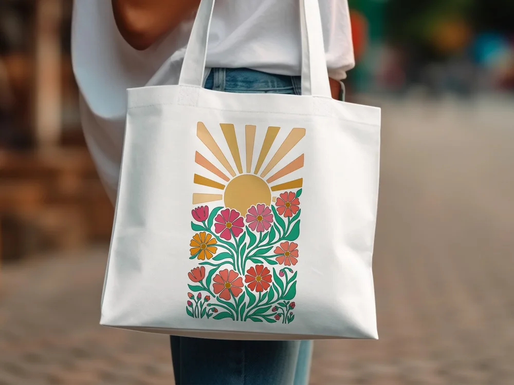 White canvas tote bag with colorful floral sunburst graphic design.