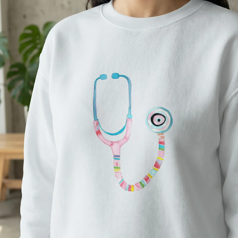Watercolor stethoscope illustration on a white crewneck sweatshirt.