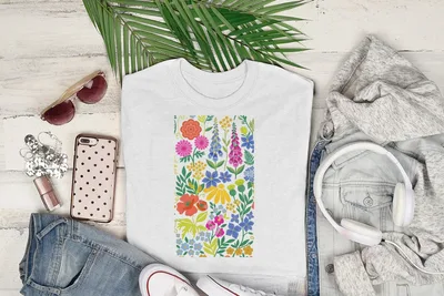 White t-shirt with colorful floral pattern, sunglasses, headphones, and denim.