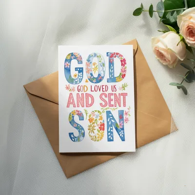 Greeting card with "GOD LOVED US AND SENT SON" text and floral watercolor design.