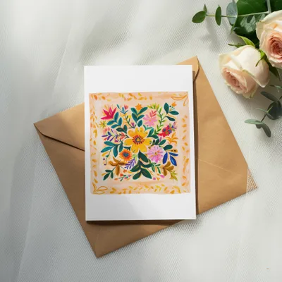 Card with colorful floral painting on a brown envelope with roses.