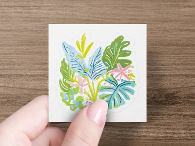 Hand holding a square sticker with a stylized tropical floral design.