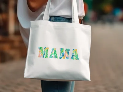 White tote bag with colorful "MAMA" text in tropical leaf pattern.