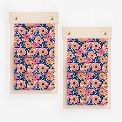 Two fabric swatches with a floral pattern of pink, blue, and orange flowers.