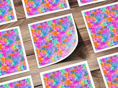 Multiple square stickers with a vibrant floral pattern on a wooden background.