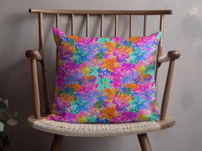 Throw pillow with a vibrant floral pattern on a wooden chair.