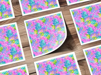 Colorful floral pattern on square cards scattered on a wooden surface.