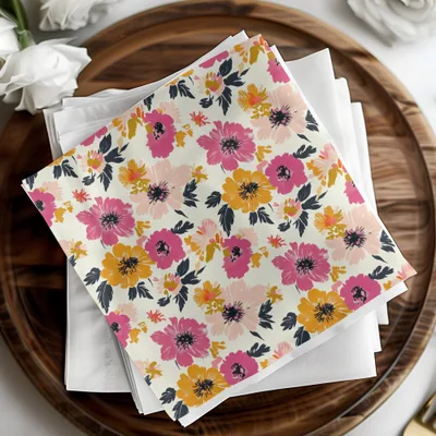 Floral patterned cloth napkin with pink, orange, and yellow flowers on a wooden tray.