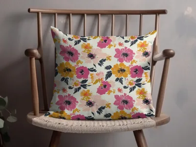 Decorative throw pillow with a pink, yellow, and coral floral pattern.
