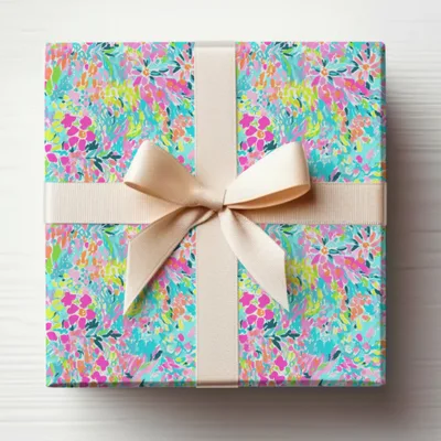 Gift box with vibrant floral pattern and cream ribbon bow.