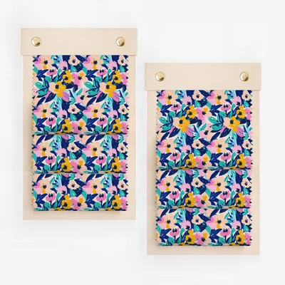 Two fabric swatches with a vibrant floral pattern in blue, pink, and yellow.