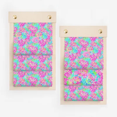 Two fabric swatch books showcasing vibrant pink, blue, and green floral pattern.