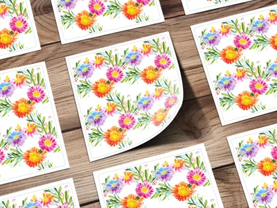 Watercolor floral pattern on white cards, arranged diagonally on a wooden surface.