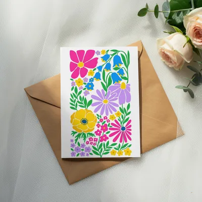 Card with colorful floral illustration on brown envelope, with roses and eucalyptus.