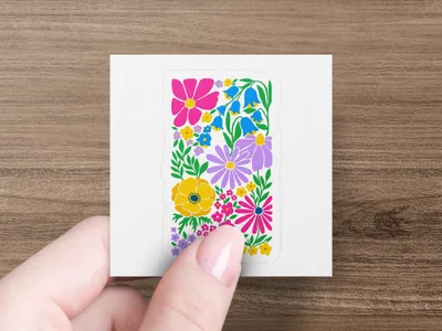 Floral sticker with pink, yellow, and purple flowers held by fingers.