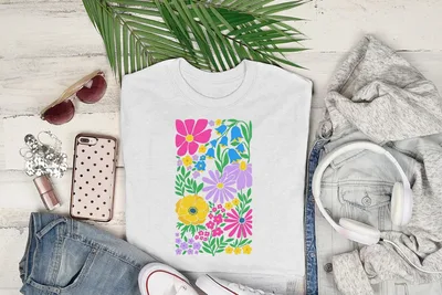 White t-shirt with colorful floral pattern and green leaves.