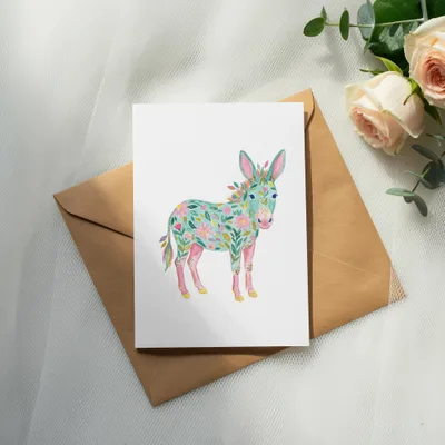 Watercolor donkey illustration with floral pattern on brown envelope and pink roses.